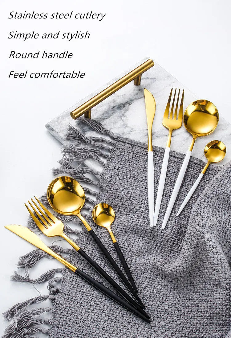 Gold and black cutlery set on a gray textured surface with marble background