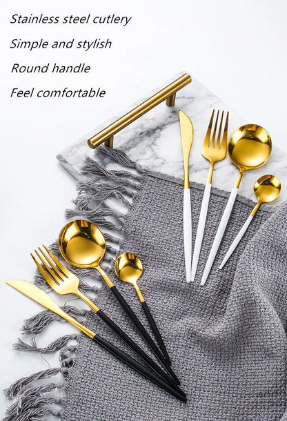 Gold and black cutlery set on a gray textured surface with marble background